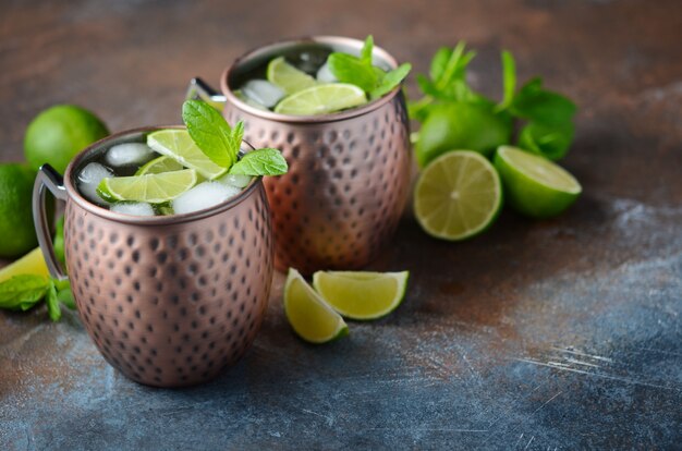 Moscow mule cocktail with ginger beer, vodka, lime and mint in a cooper mugs