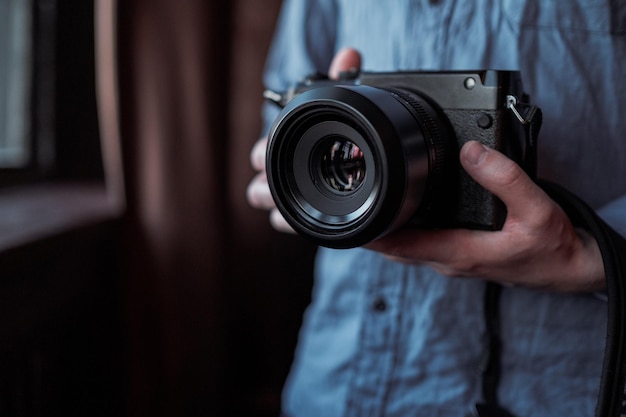 MOSCOW RUSSIA 14 MARCH 2019 Fujifilm GFX50s Camera Fujifilm Mirrorless Closeup of hand holding camera Mirrorless camera close up in the hand of a young man on a studio background