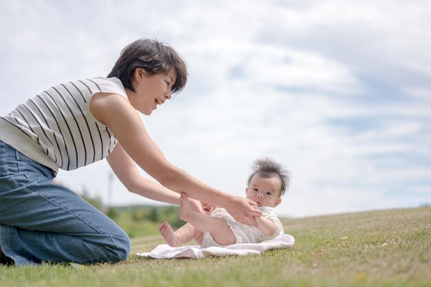 A mother and baby playing on the grass