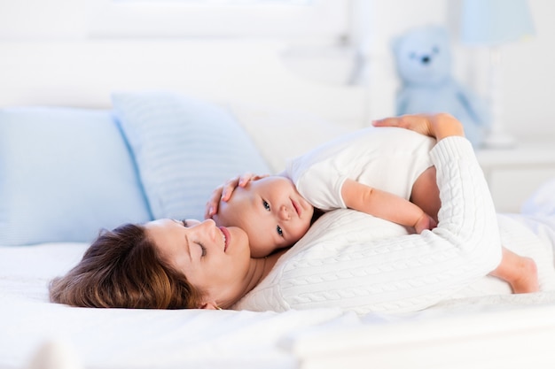 Mother and baby on a white bed