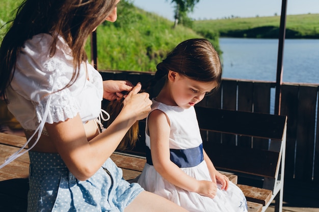 Mother braids hair daughter