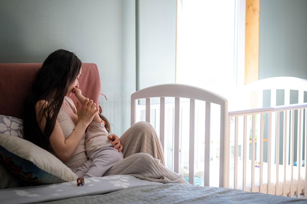 Mother breastfeeding baby in her arms at home beautiful mom breast feeding her toddler child baby eating mother milk young woman nursing and feeding baby lactation infant