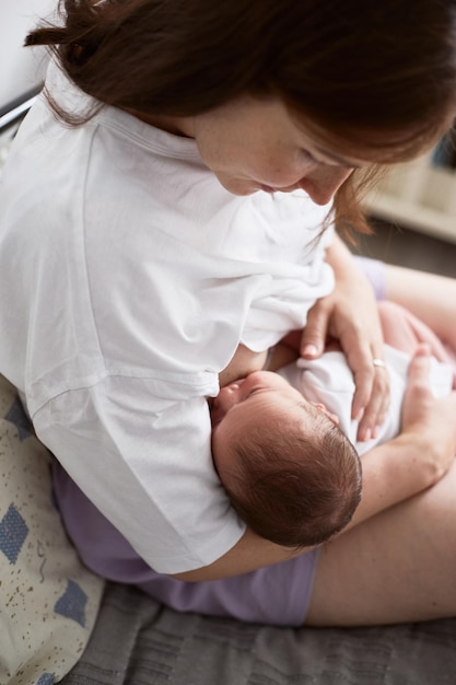 Mother breastfeeding her newborn baby boy Realistic home portrait