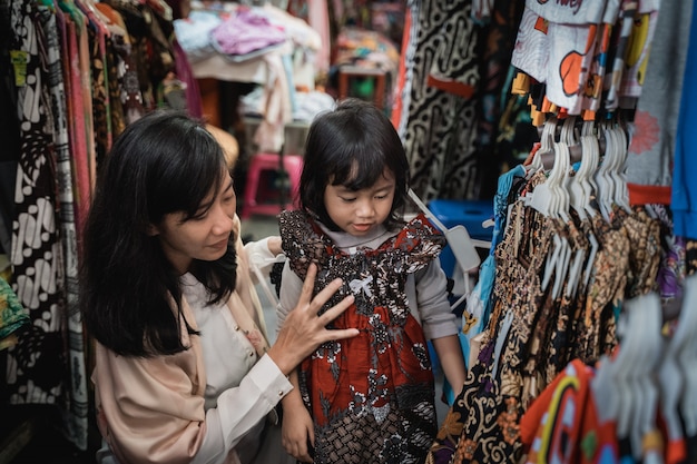 Mother buy and try batik for her daughter