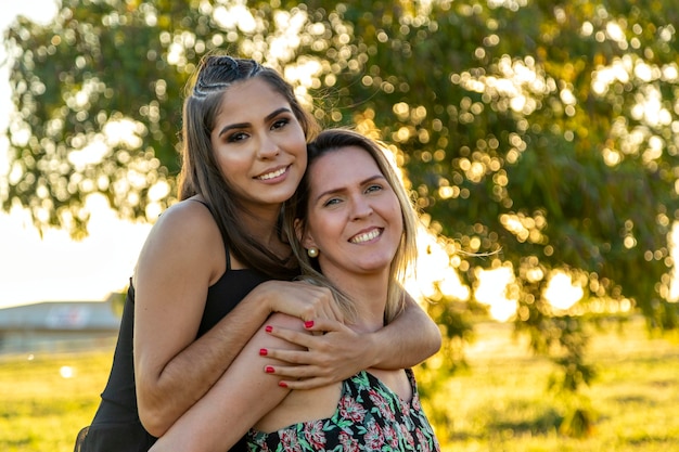 Mother carrying daughter at sunset.