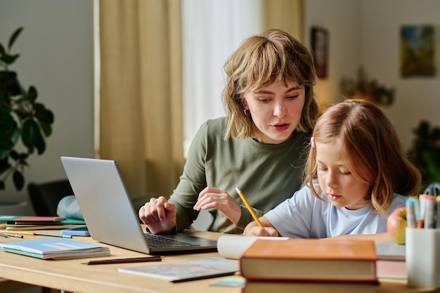 Photo mother checking daughters homework