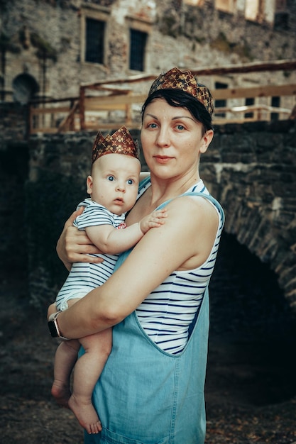 mother and child in crowns on the background of an ancient castle. Prince and Queen