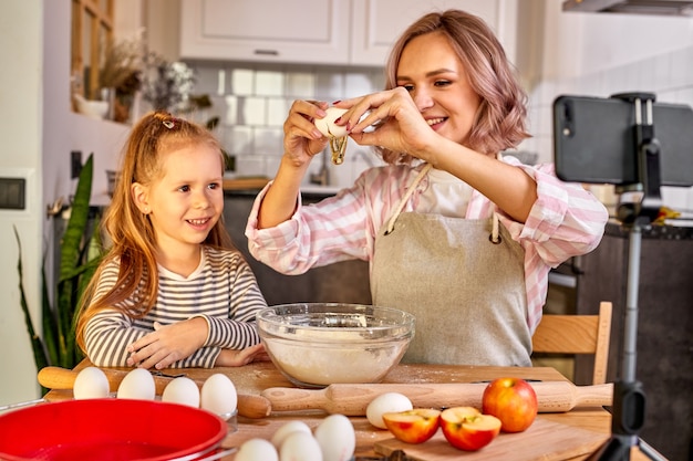 Mother and child daughter are going to cook, bake cookies at home