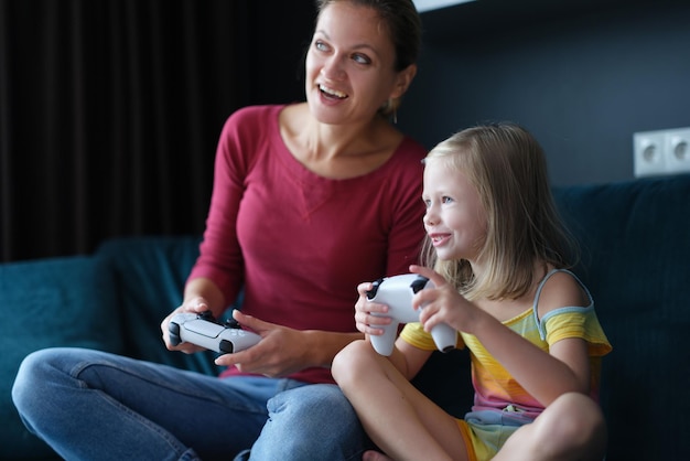 Mother and child girl playing video games