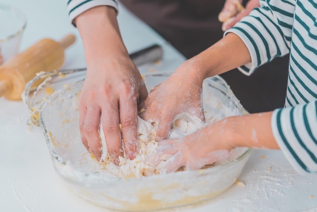 Mother and child hand working together to mix flour and ingredient for Cooking and Baking bakery in home kitchen