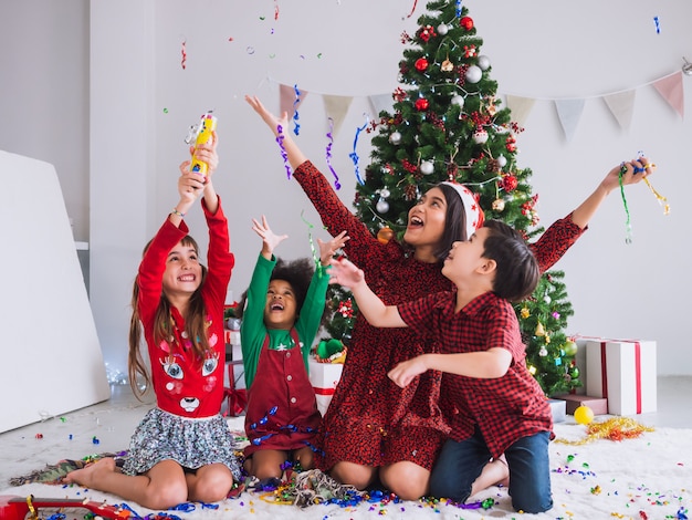 Mother and children are celebrating Christmas and having fun and happy in the house with christmas tree