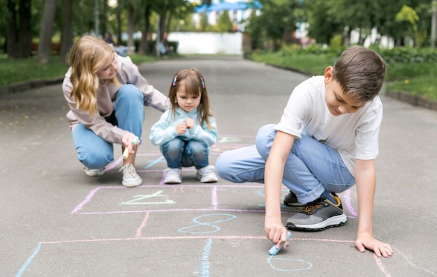 Mother and children playing hopscotch