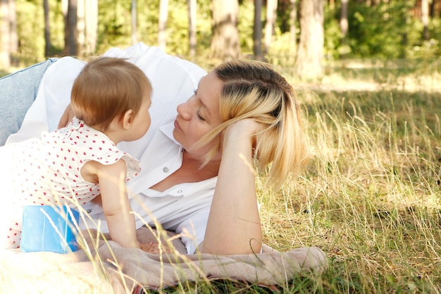 mother communicates with little daughter in the park on a sunny day