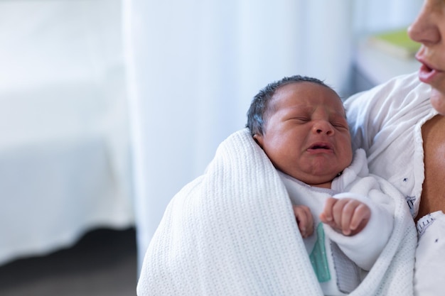 Mother consoling newborn baby in hospital