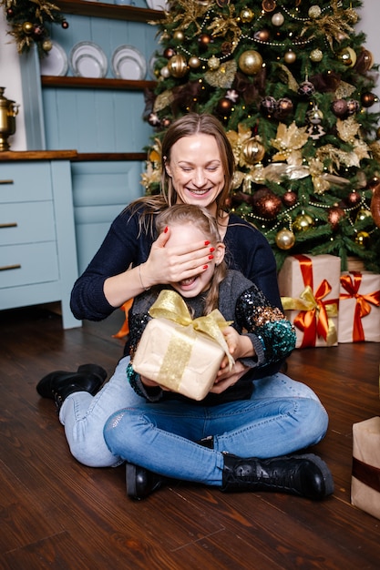 Mother covers her daughter's eyes and going to make surprise for daughter