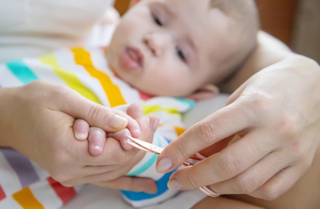 Mother cuts little baby's nails Selective focus