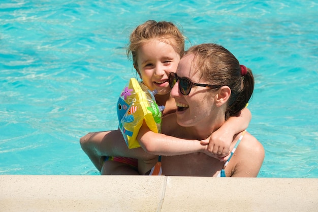 Mother and daughter are having fun in the pool