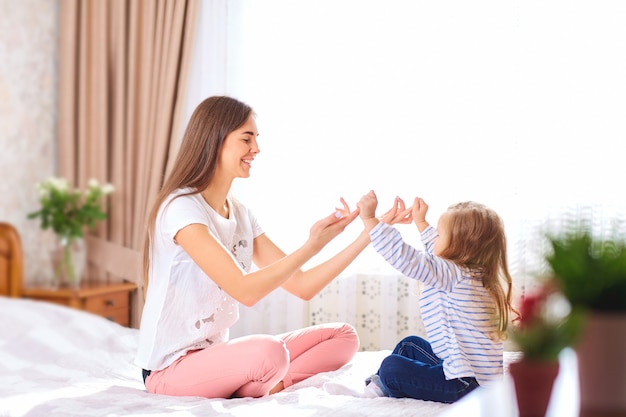 Mother and daughter on the bed by the window