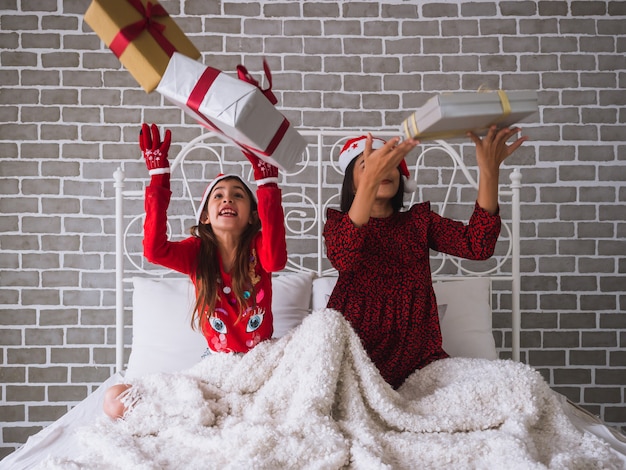 Mother and daughter celebrate Christmas by throwing a gift box into the air