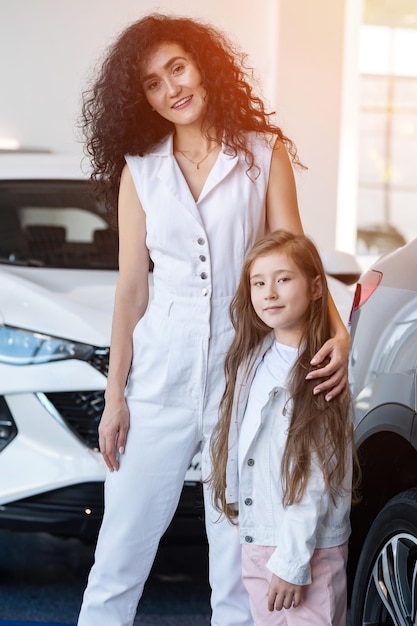 Mother and daughter choose car together in auto showroom