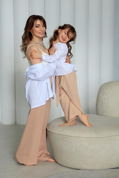 Mother and daughter in classic clothes at home in a beautiful interior