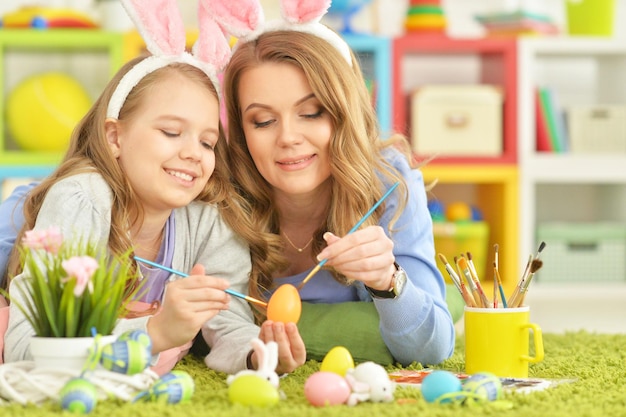 Mother and daughter colouring eggs to Easter