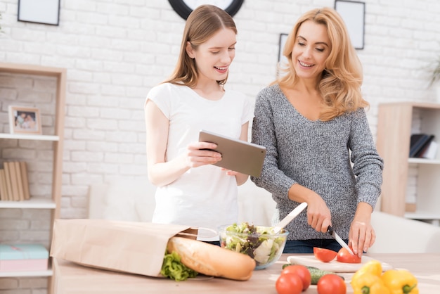 Mother and Daughter Cooking Together in Kitchen.