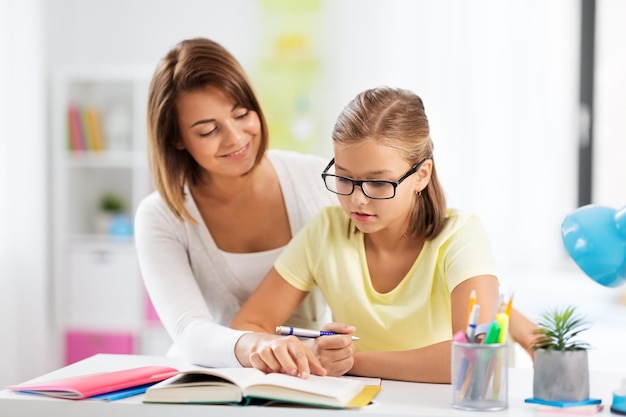 Photo mother and daughter doing homework together