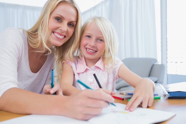 Mother and daughter drawing together in the living room