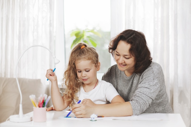 mother and daughter drawing together