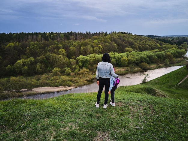 Mother and daughter enjoys the view on the coast Sluch river