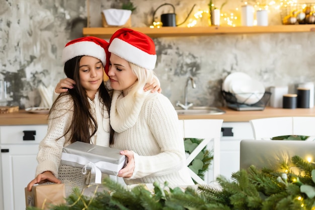 Mother and daughter in front of Christmas tree.