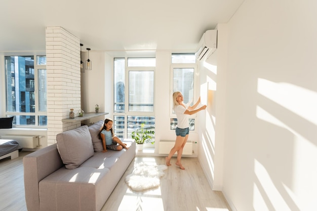 mother and daughter hangs a large photo canvas at home