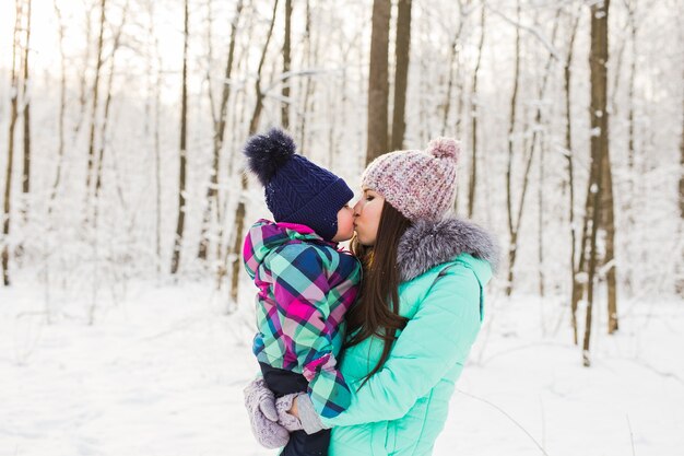 Mother and daughter having fun in the winter park.