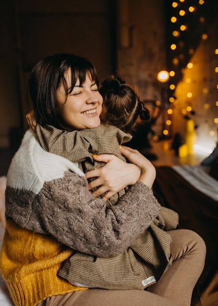 Mother and daughter at home, hugging each othersmiling