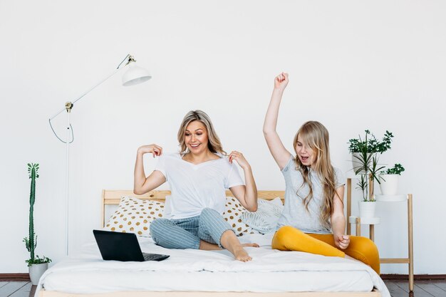 Mother and daughter at home with laptop