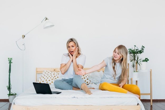 Mother and daughter at home with laptop