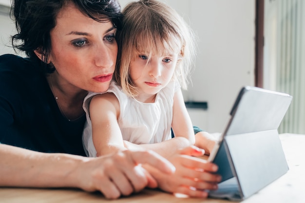 Mother and daughter indoor using tablet