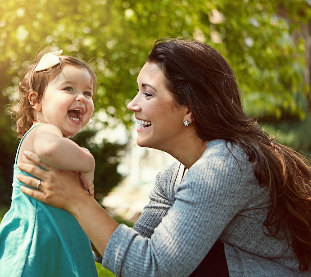 Mother daughter and laughing with playing in garden for fun activity bonding and smile outdoor in home Happy family woman and child in park with care explore and funny with embrace in nature