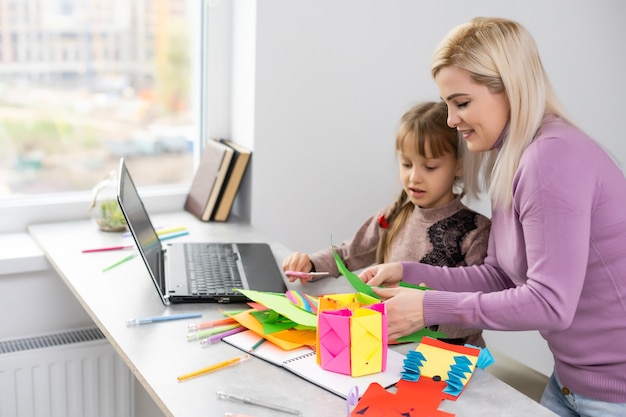 mother and daughter make paper crafts together