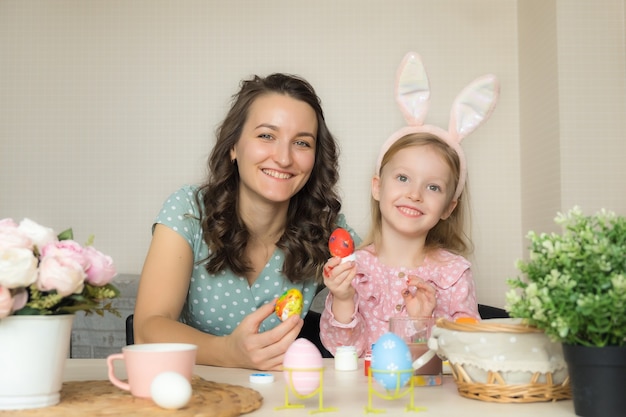 Mother and daughter painting eggs for Easter