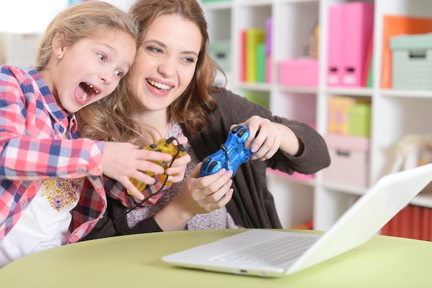 Mother and daughter playing game on laptop