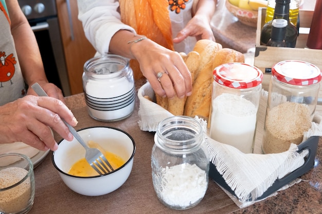 Mother and daughter prepare together the meal in the kitchen.