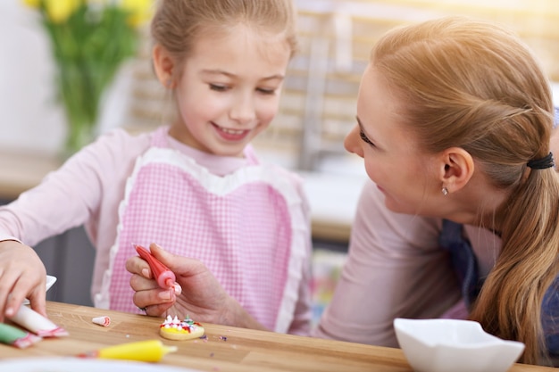 mother and daughter preparing cookies in the kitchen