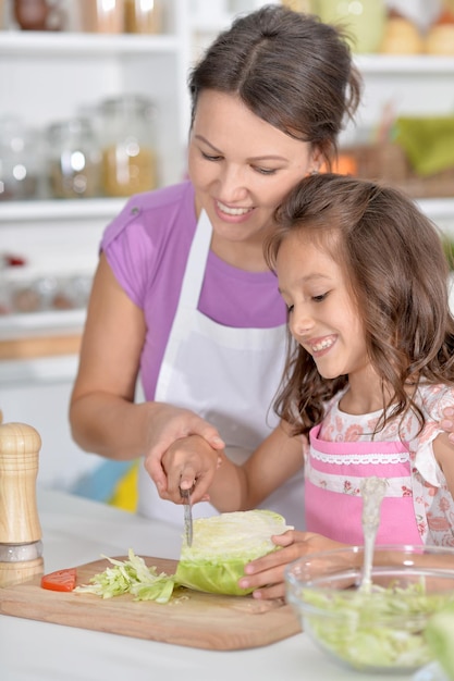 Mother and daughter preparing dinner together on kitchen