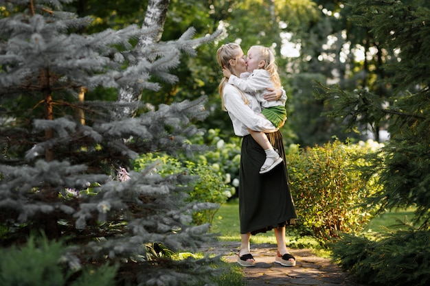 Mother and daughter in the same clothes in the summer on a walk in the park