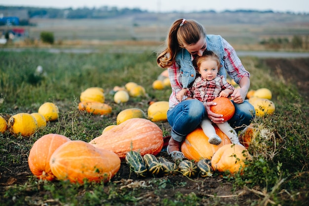 Mother and daughter sitting on pumpkins, Halloween eve