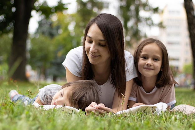 Mother and daughter sitting together on green grass. Mother and daughter having funny conversation