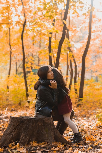 Mother and daughter spend time together in autumn yellow park Season and single parent concept