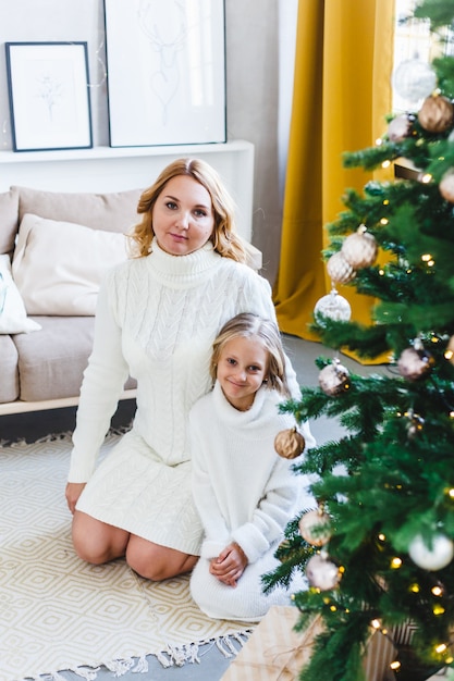 Mother and daughter standing near the Christmas tree